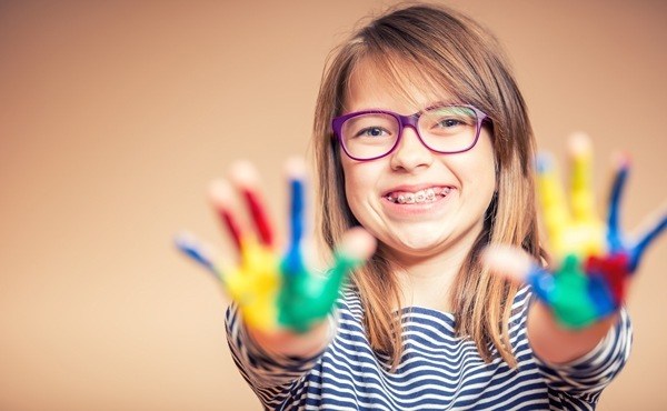 girl with braces showing painted hands